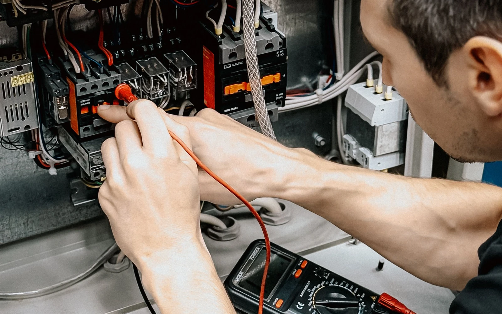 Diagnostic électrique au multimètre dans un tableau ouvert